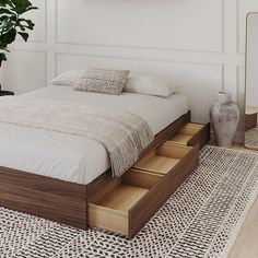 a bed sitting on top of a wooden platform next to a mirror and potted plant