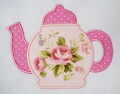 a teapot with pink flowers and polka dot trimmings on it's side