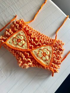 an orange crocheted purse sitting on top of a table