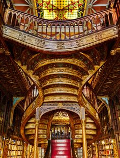 the interior of a large library with many bookshelves and stained glass window above it