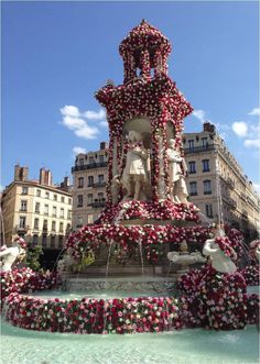 there is a fountain with flowers all over it