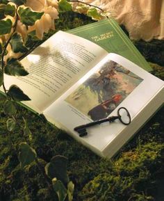 an open book with a pair of scissors laying on top of it next to some flowers