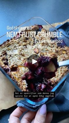 a person holding a glass dish with food in it and the words nem fruitcrumbble written below