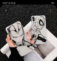 someone holding up their phone case with the iron man design on it, while another person holds