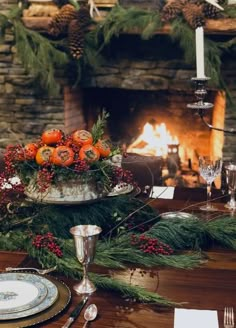 the table is set with silverware and oranges in an old - fashioned bowl