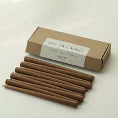 several brown candles sitting in front of a cardboard box