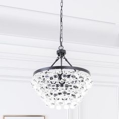 a chandelier hanging from the ceiling in a room with white walls and flooring