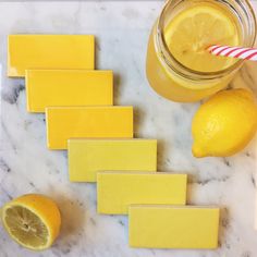 some lemons are sitting on a marble counter top next to a jar of liquid