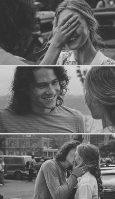 black and white photo of two people kissing each other in front of a city street