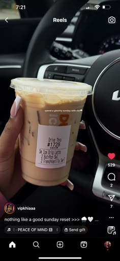 someone holding up a cup of iced coffee in their hand and the text on it