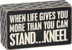 a wooden block that says, when life gives you more than you can stand knel