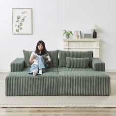 a woman sitting on top of a green couch