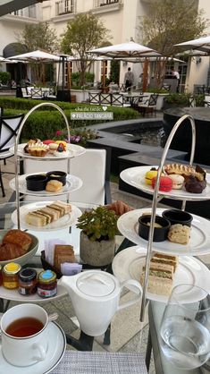 a table topped with plates and cups filled with food next to each other on top of a glass table