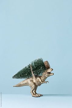 a toy dinosaur with a christmas tree on its back