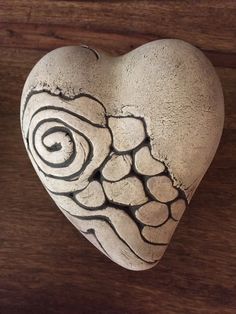 a heart shaped stone sitting on top of a wooden table