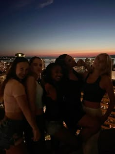 group of people posing in front of the city at night