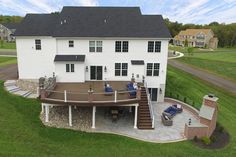 an aerial view of a large white house with stairs leading up to the upper level