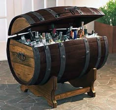 a wooden barrel filled with lots of bottles and liquor sitting on top of a table