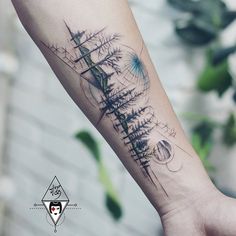 a person with a tattoo on their arm that has trees and mountains in the background