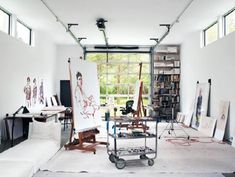 an artist's studio with lots of art work on the walls and in the floor