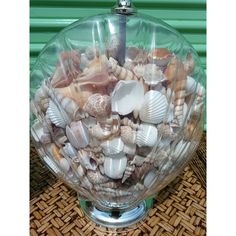 a glass bowl filled with lots of sea shells