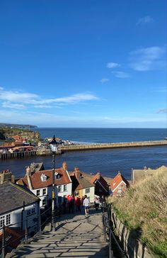 people are walking up and down the stairs to the water's edge with houses on either side