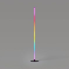 a multicolored stick is standing upright on a gray surface with no one around it