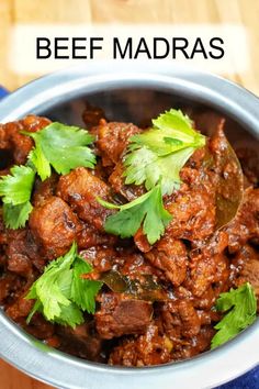 a bowl filled with meat and cilantro on top of a blue cloth next to a