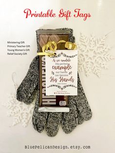 a pair of gloves sitting on top of a white table next to a card with the words printable gift tags