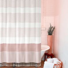 a bathroom with pink walls and a shower curtain