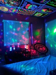 a bedroom with colorful lights on the ceiling