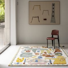 a chair sitting in front of a painting on the wall