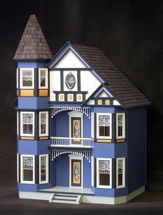 a blue and white doll house with two story windows on the second floor is shown in front of a black background