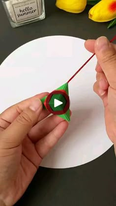 someone is making a paper origami flower on a table with flowers in the background