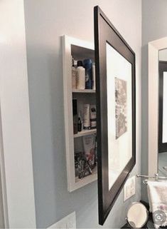 a bathroom with a sink, mirror and shelf above it's toilet paper dispenser