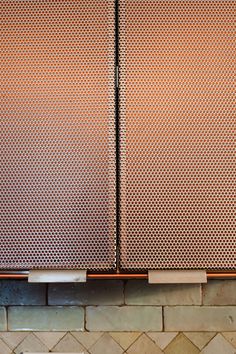 two metal cupboards sitting next to each other on a tiled wall in a kitchen