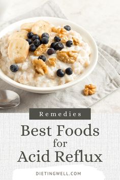 a bowl of oatmeal with blueberries and bananas on top, next to a spoon