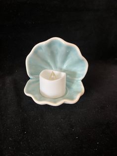 a white candle holder sitting on top of a black table