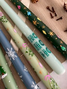 four candles are lined up on a table with christmas decorations and candy canes in the background