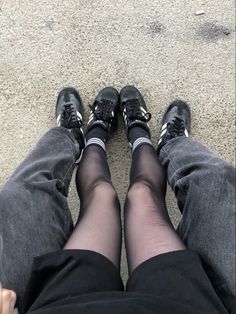 two people with their legs crossed wearing black shoes