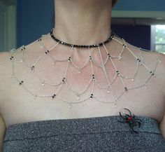 a close up of a woman wearing a necklace with beads and chains on her chest