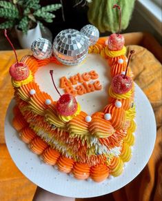 a heart shaped cake decorated with fruit and disco balls