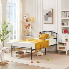 a child's bedroom with white walls and flooring, including a black metal bed frame