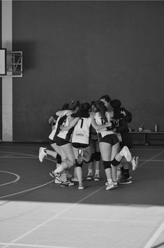 a group of young women standing on top of a basketball court next to each other