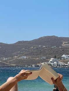 a person is reading a book on the beach