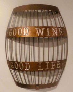 a wine barrel hanging on the wall with good wine written on it's side