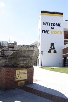 a large rock sitting in front of a building