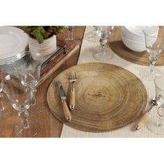 a wooden table topped with plates and silverware