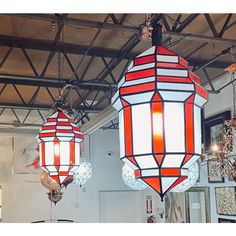 two chandeliers hanging from the ceiling in a room with mirrors and other decorations