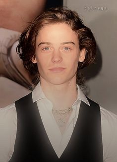 a young man wearing a black vest and white shirt